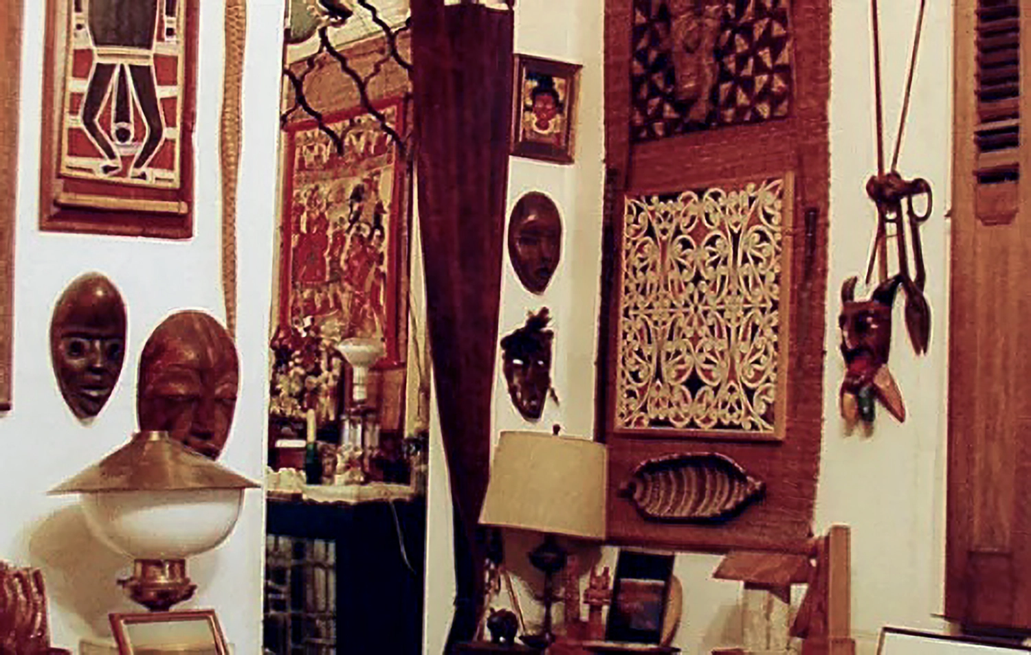 A room filled with what appears to be indigenous artworks, woven vessels, and African masks.